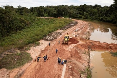 aerial view of people working on a road in the rainforest