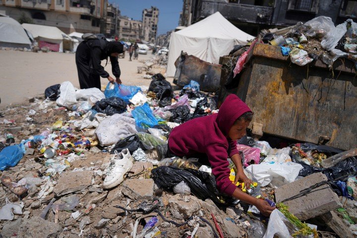 Palestinos buscan comida entre la basuar. Foto: AP 