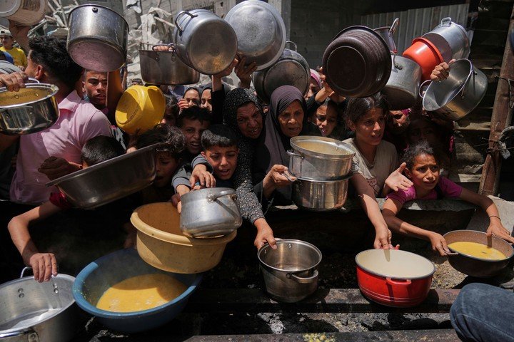 Palestinos piden comida en una cocina comunitaria. Foto: AP