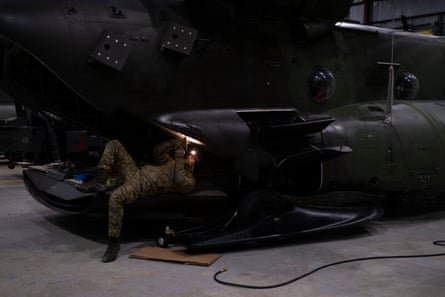 A soldier works to repair a Chinook transport helicopter.