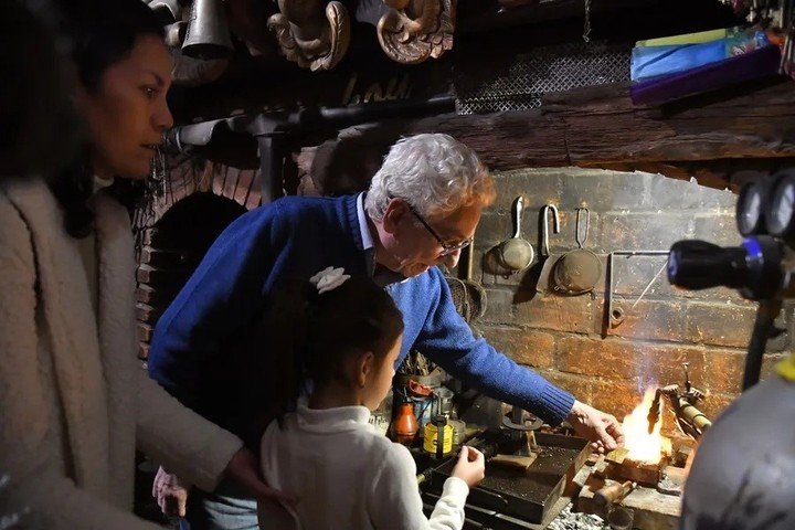 El orfebre Juan Carlos Pallarols (c) enseñando a una niña en su taller en el barrio San Telmo, en Buenos Aires, Argentina. EFE/ Enrique Garcia Medina