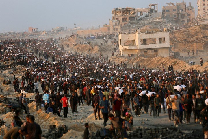 Palestinians cargan bolsas de alimentos entregados por organizaciones de ayuda humanitaria, en Beit Lahia, en el norte de la Franja de Gaza. Foto: REUTERS 