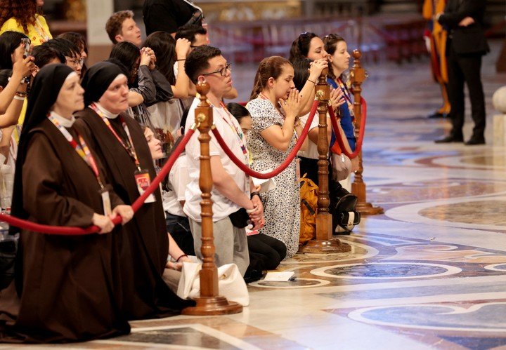 Jóvenes misioneros influencers rezan en San Pedro. Foto: Reuters