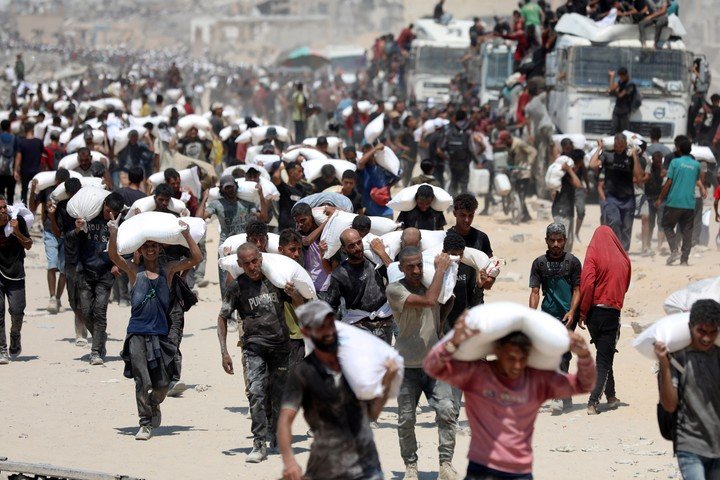 Palestinos cargando bolsas de harina después de que la ayuda humanitaria entrara en Gaza. Foto: Xinhua.