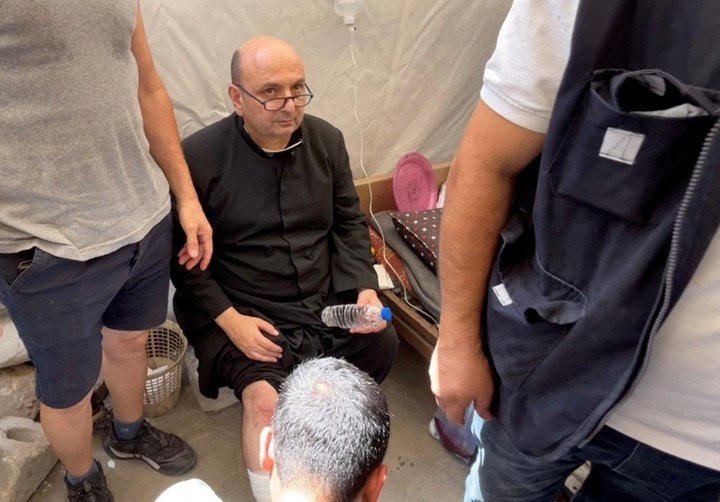 El párroco Gabriel Romanelli mientras recibía atención médica tras el bombardeo del 17 de julio. Foto: Dawoud Abu Alkas/ Reuters.