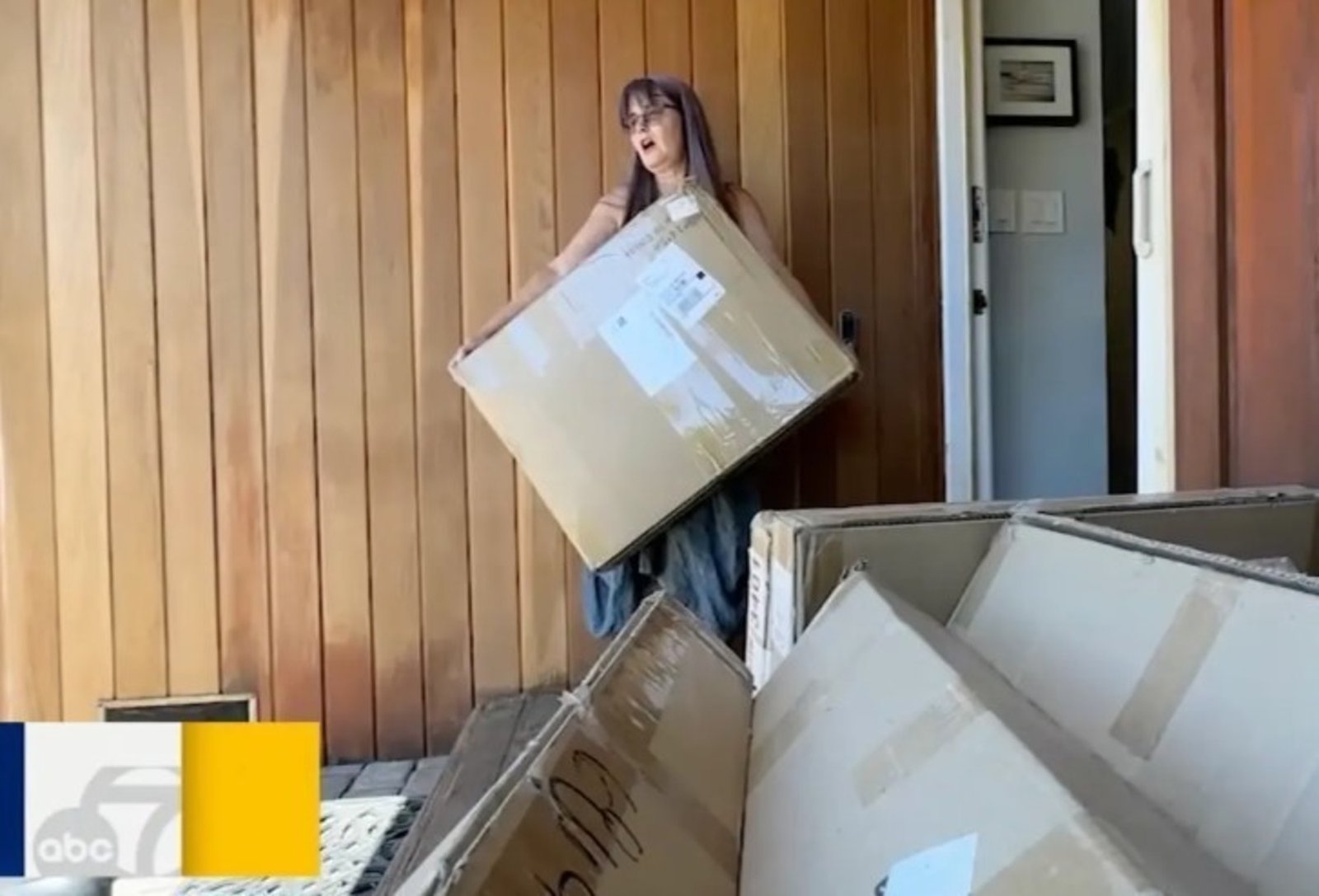 Kay, trasladando una de las tantas cajas que, equivocadamente, llegan a su casa. Foto: ABC 7 