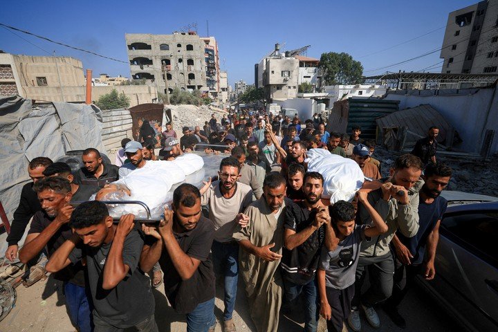 Palestinos cargan los cuerpos de dos personas muertas en bombardeos de Israel en Ciudad de Gaza, este jueves. Foto: REUTERS 