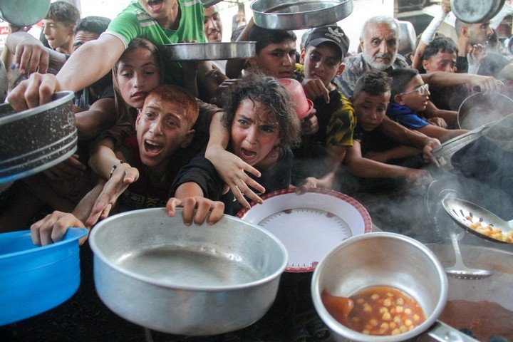 Chicos palestinos buscan comida en un centro de distribución de ayuda en Ciudad de Gaza. Foto: REUTERS