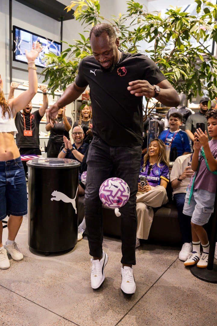 Usain Bolt intentando dominar la nueva pelota con la que se jugará la liga inglesa.